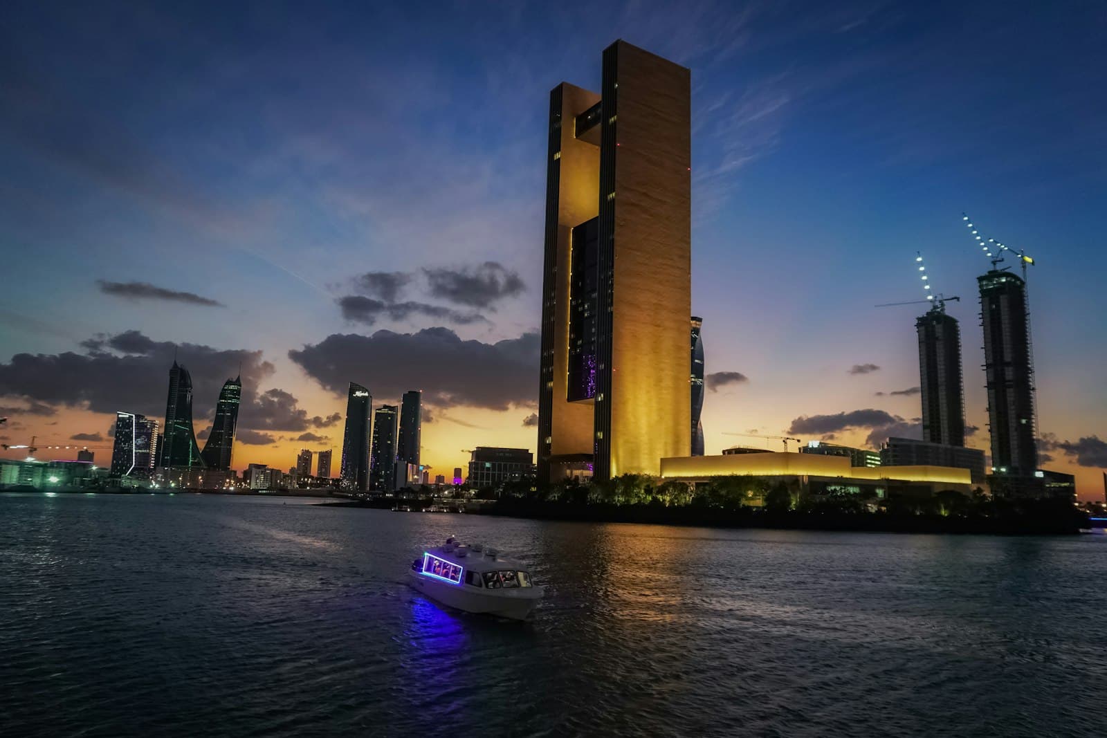 Bahrain Bay tower lit gold at dusk
